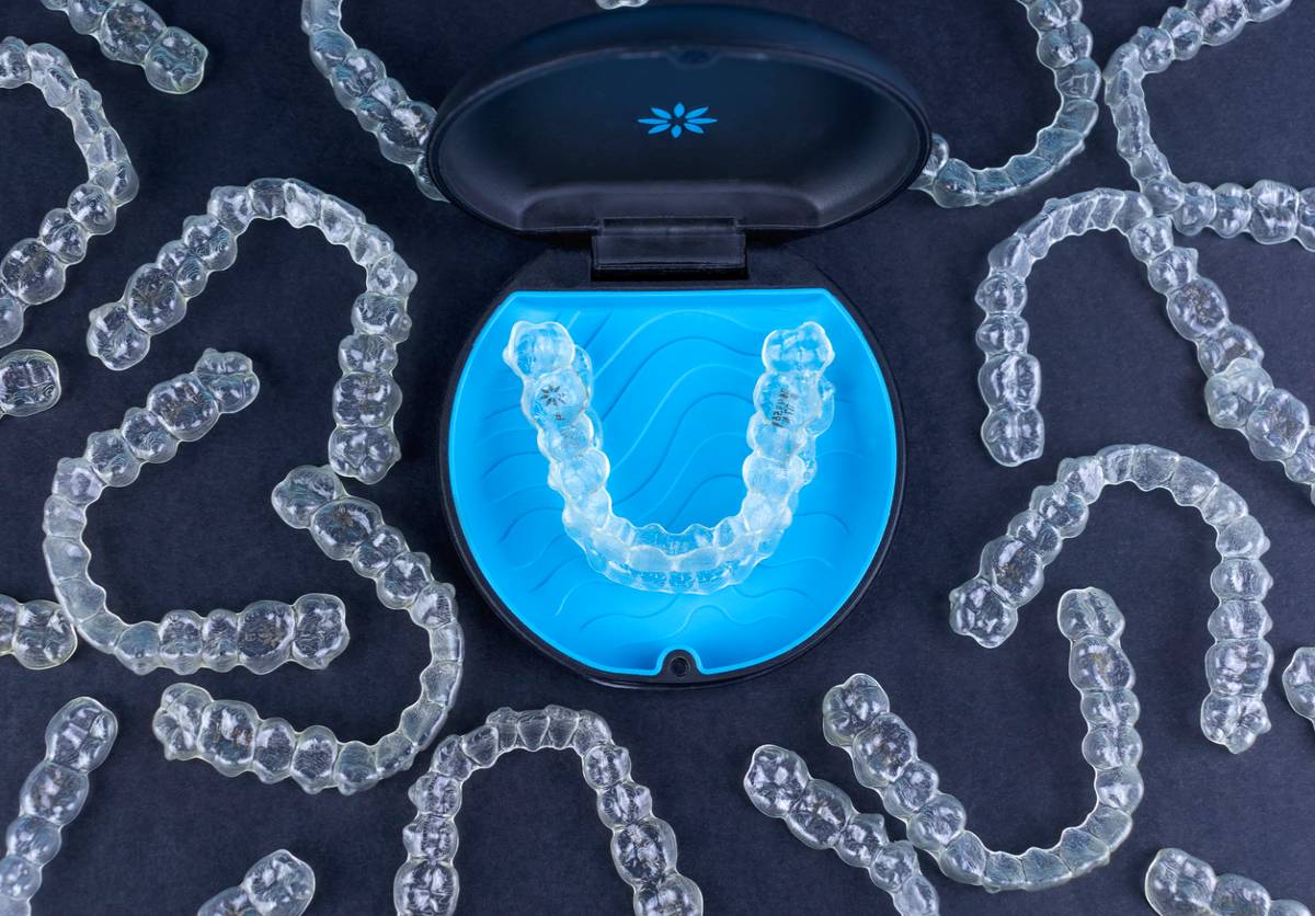 Many invisalign treatment retainers on blue background